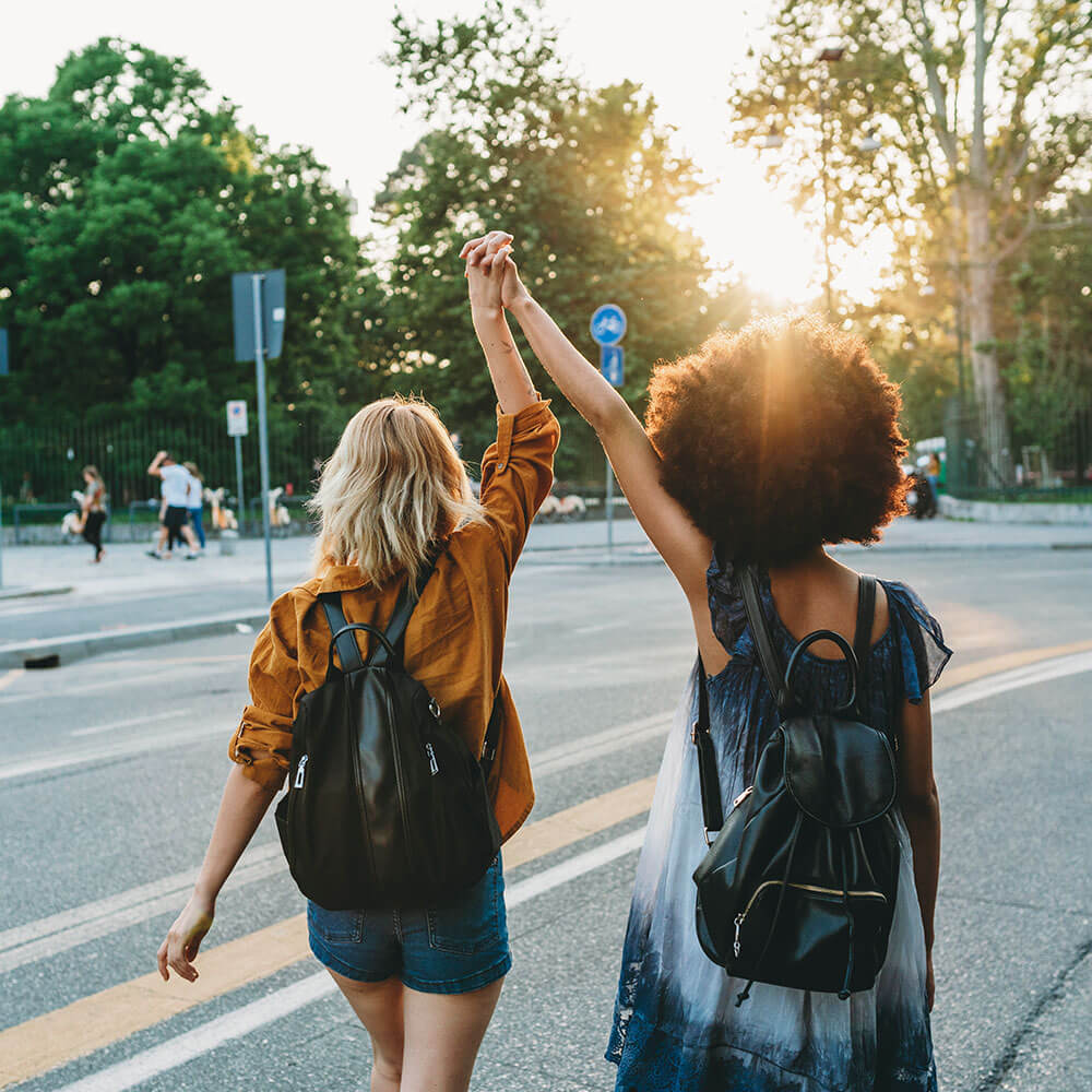 Two friends walking together in the city at sunset