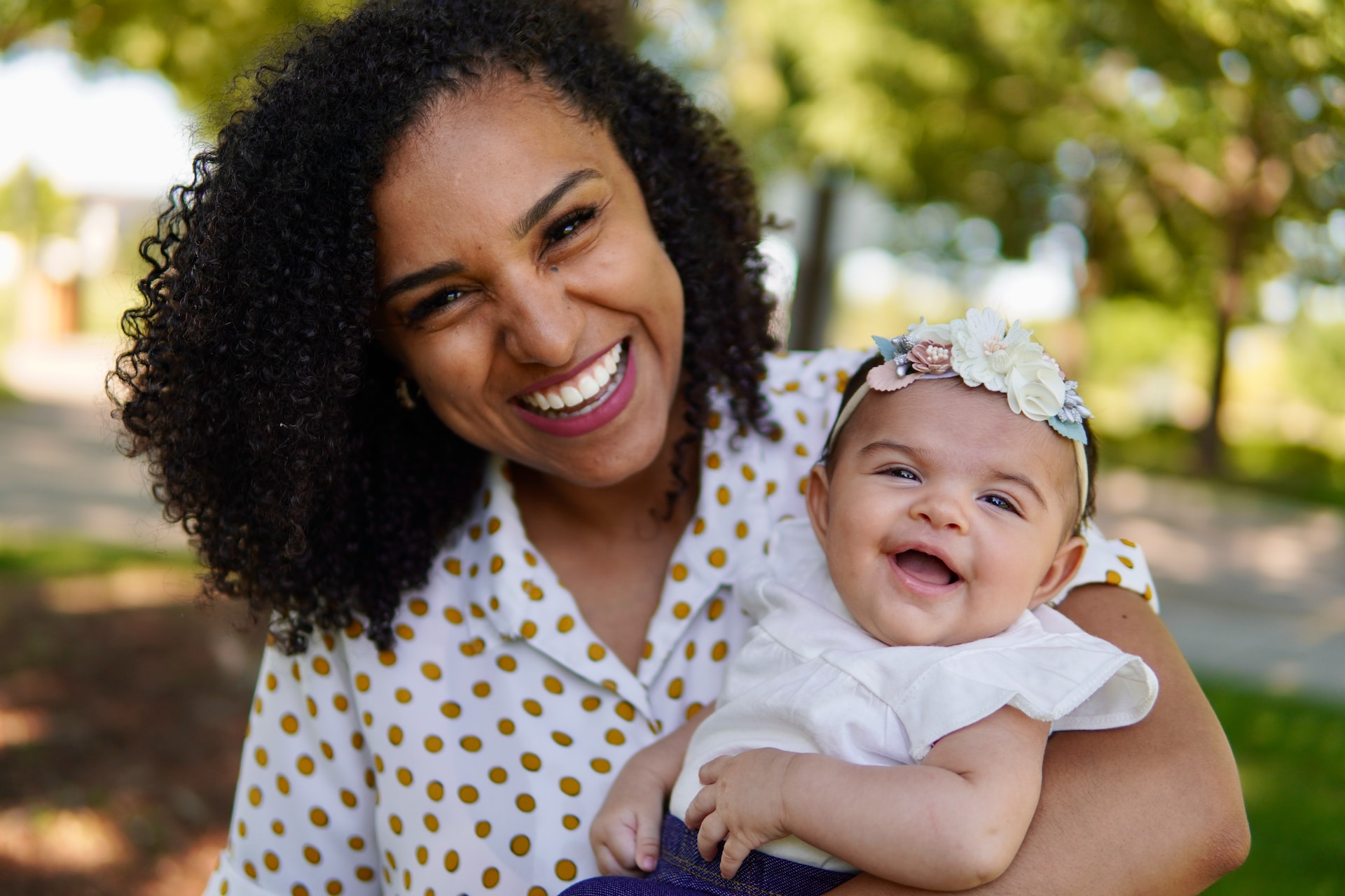 Smiling black mother and baby in a park